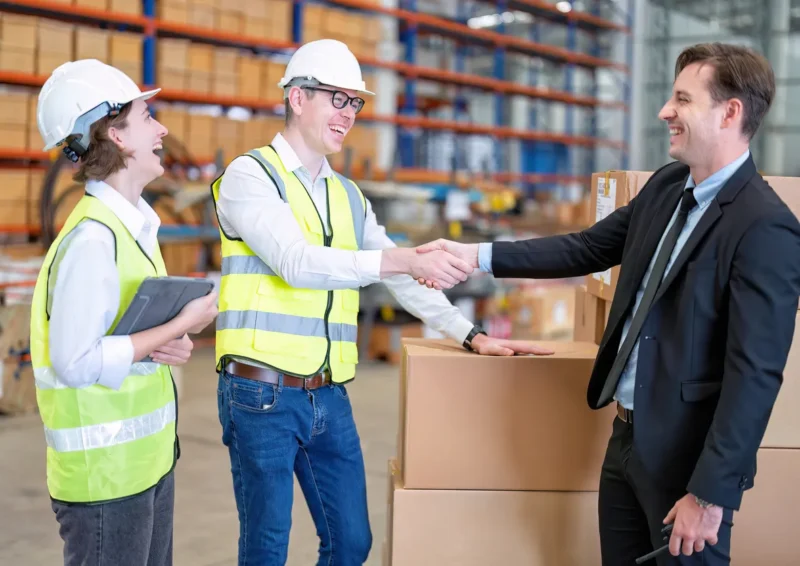 Samenwerking tussen opdrachtgever en medewerkers in een magazijnomgeving.